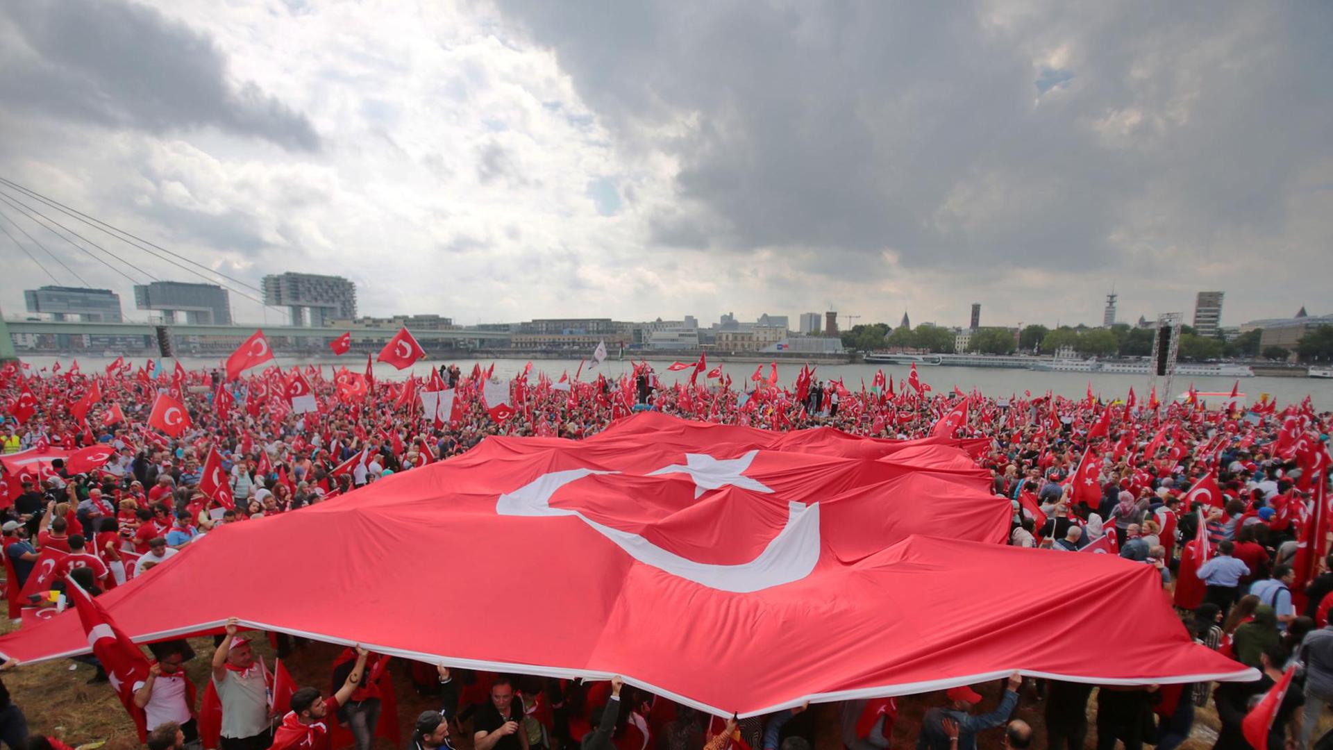 Anhänger des türkischen Staatspräsidenten Erdogan schwenken am 31.07.2016 in Köln Fahnen. Doch es gibt auch genug Gegner. Anhänger des türkischen Staatspräsidenten Erdogan schwenken am 31.07.2016 in Köln Fahnen. Doch es gibt auch genug Gegner.