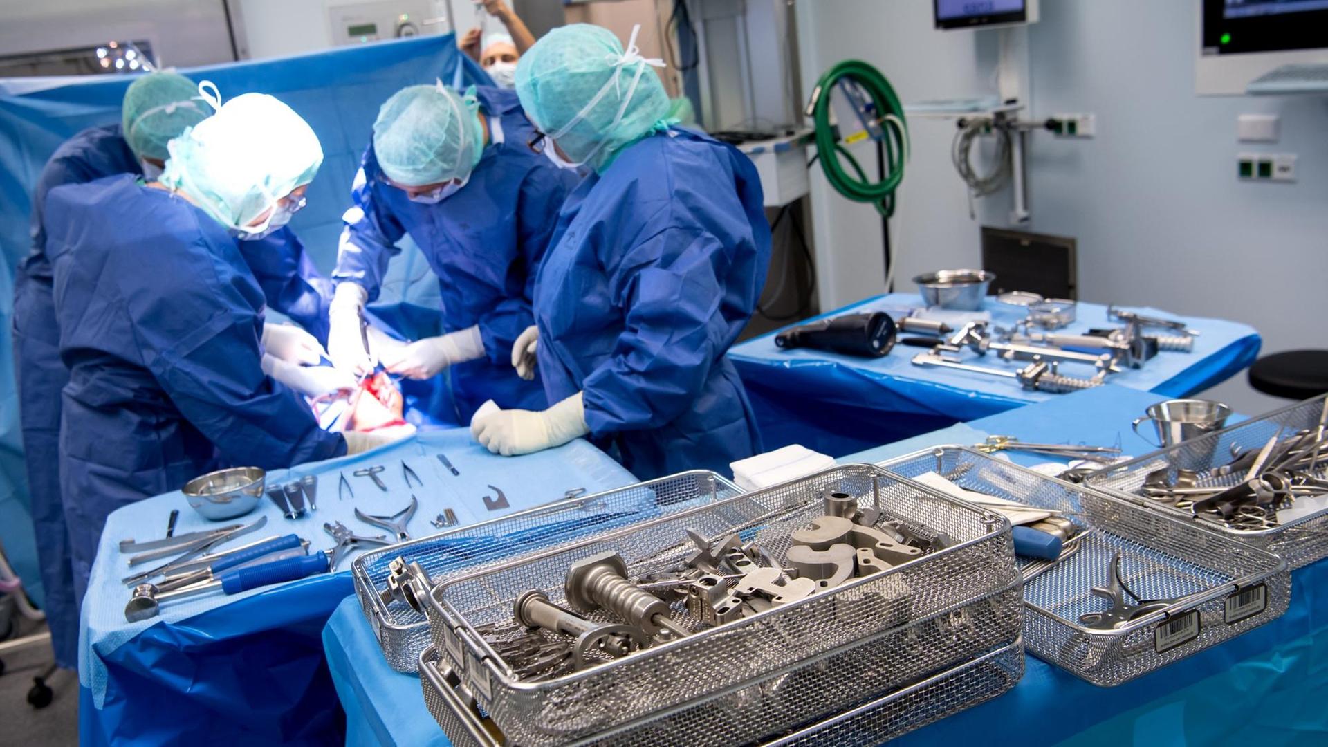 Ein Ärzteteam setzt einem Patienten während einer Knie-Operation in der Sana Klinik (OCM - Orthopädische Chirurgie München) in einem Operationssaal eine Knietotalendoprothese (Knie-TEP) ein.