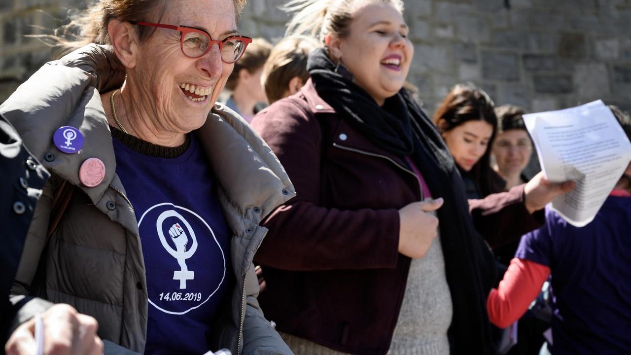 Frauen haben sich eingehakt und marschieren gemeinsam. am 14. Mai 2019 in Lausanne.