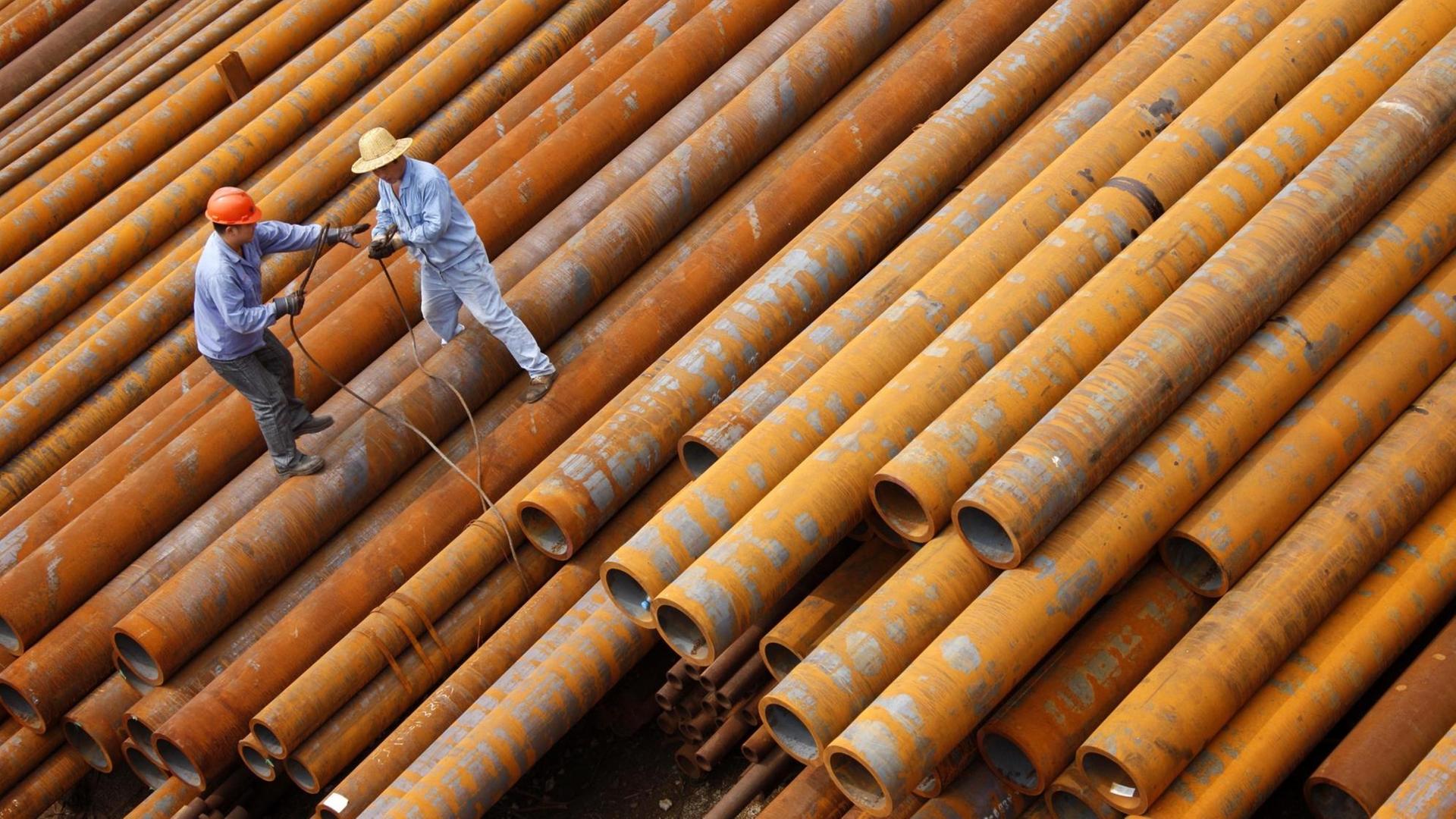 Chinesische Arbeiter in Huaibei bewegen sich auf rieigen Stahlrohren. Chinesische Arbeiter in Huaibei bewegen sich auf rieigen Stahlrohren.
