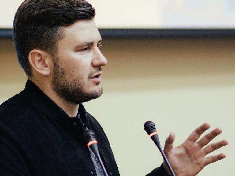 Der russische Bestseller-Autor und Journalist Dmitry Glukhovsky spricht in ein Mikrofon.