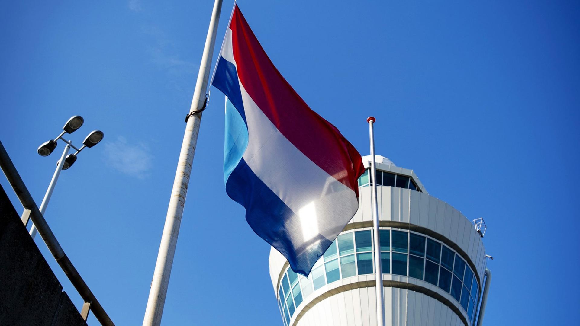 Die niederländische Flagge weht auf Halbmast vor dem Tower des Flughafens Schiphol bei Amsterdam am 23.07.2014. Die niederländische Flagge weht auf Halbmast vor dem Tower des Flughafens Schiphol bei Amsterdam am 23.07.2014.