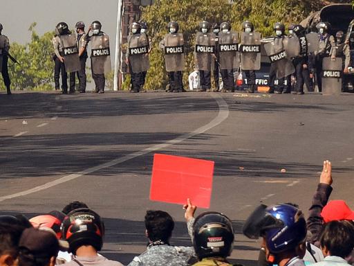 In Bago in Myanmar stehen sich am 8. März 2021 Polizei und Demonstranten auf einer Straße gegenüber.
