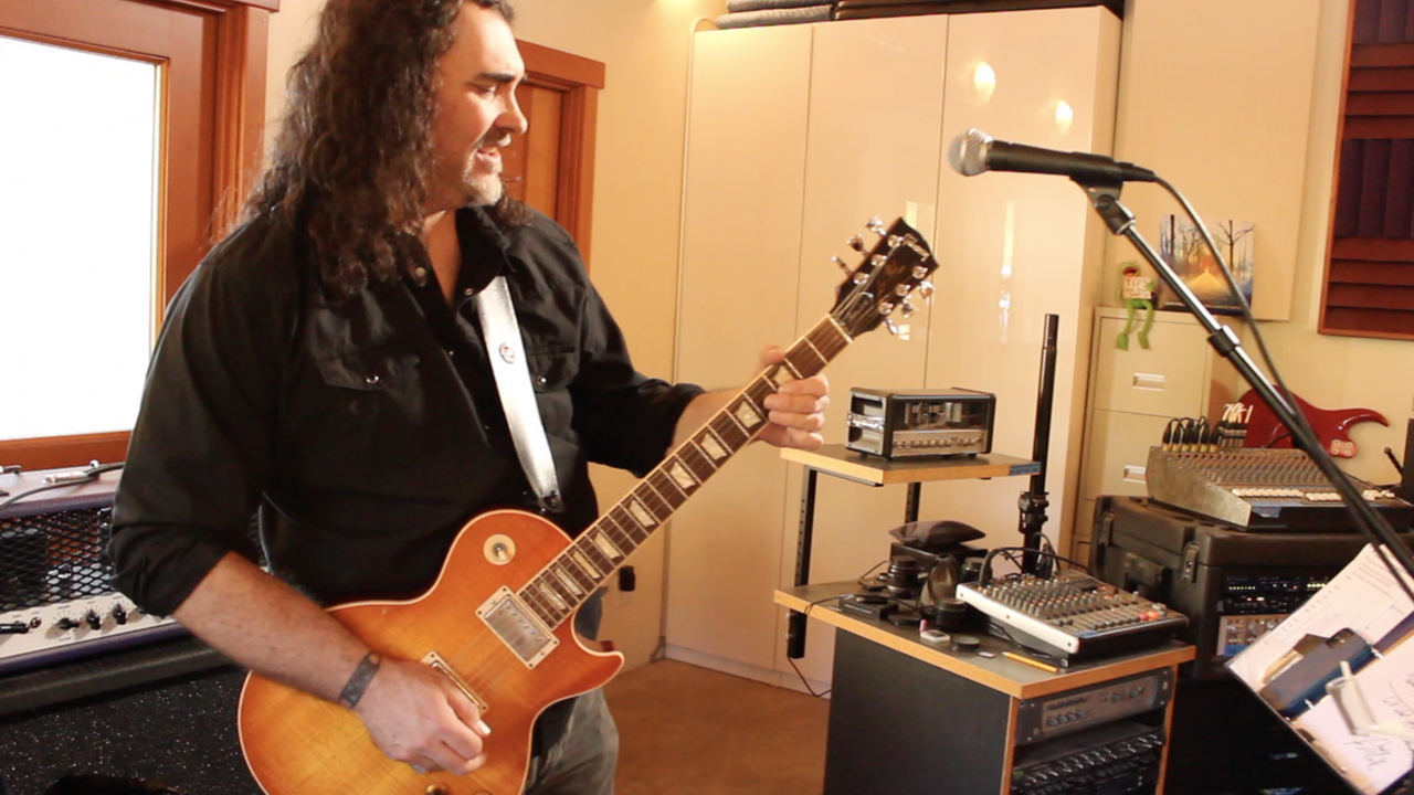 Ein Mann mit schwarzen langen Haaren steht in einem Studio vor einem Mikro und spielt E-Gitarre. Ein Mann mit schwarzen langen Haaren steht in einem Studio vor einem Mikro und spielt E-Gitarre.