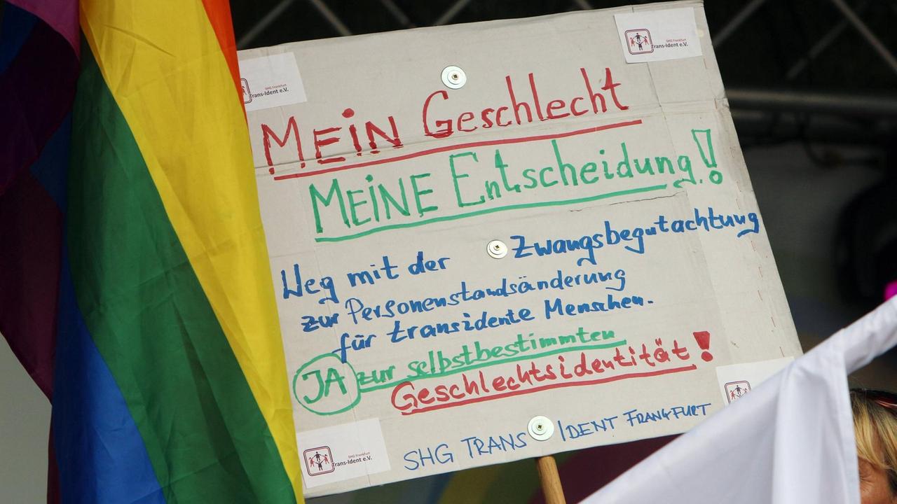Beim Christopher Street Day 2018 in Frankfurt wird ein Plakat hochgehalten mit der Aufschrift "Mein Geschlecht. Meine Entscheidung! Weg mit der Zwangsbegutachtung für transidente Personen" Beim Christopher Street Day 2018 in Frankfurt wird ein Plakat hochgehalten mit der Aufschrift "Mein Geschlecht. Meine Entscheidung! Weg mit der Zwangsbegutachtung für transidente Personen"