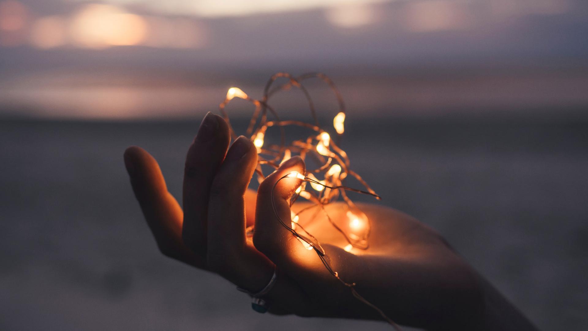 Eine Lichterkette liegt in einer Hand. Eine Lichterkette liegt in einer Hand.