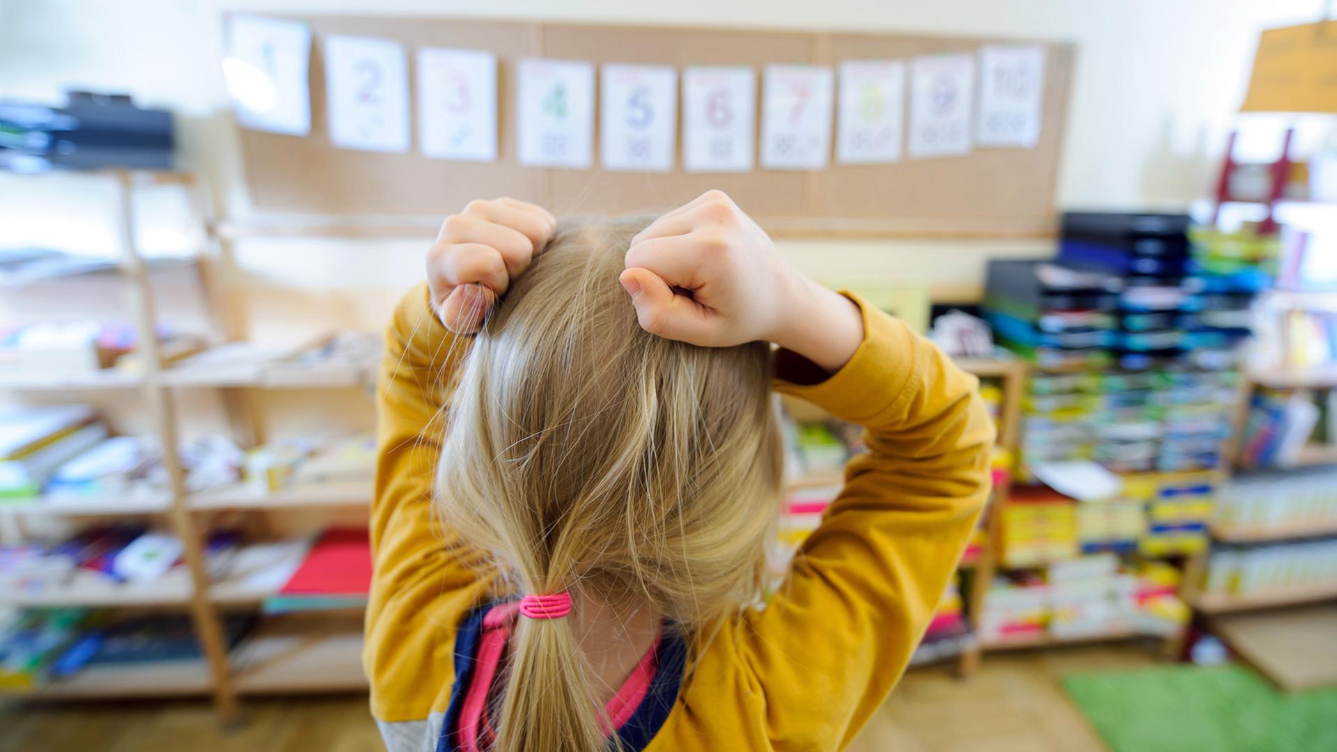 Ein Schulkind steht vor einer an der Wand aufgehängten Zahlenreihe und rauft sich die Haare. Ein Schulkind steht vor einer an der Wand aufgehängten Zahlenreihe und rauft sich die Haare.