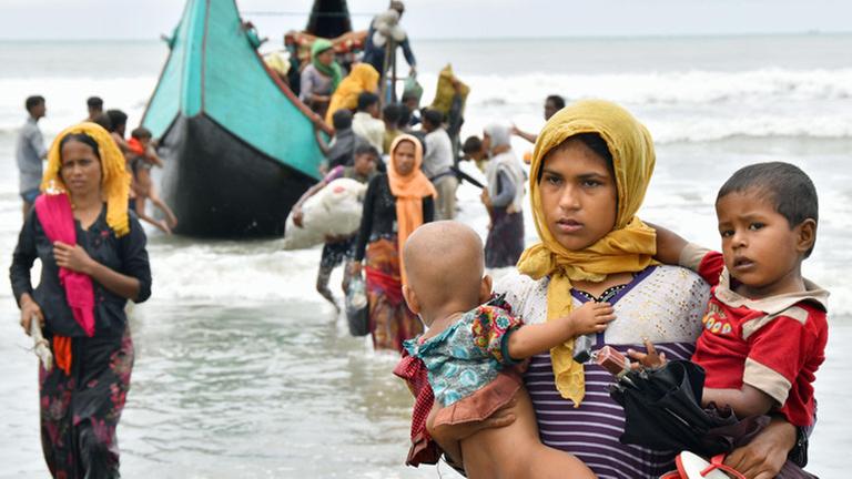 Menschen der muslimischen Minderheit Rohingya steigen aus einem Boot aus. 