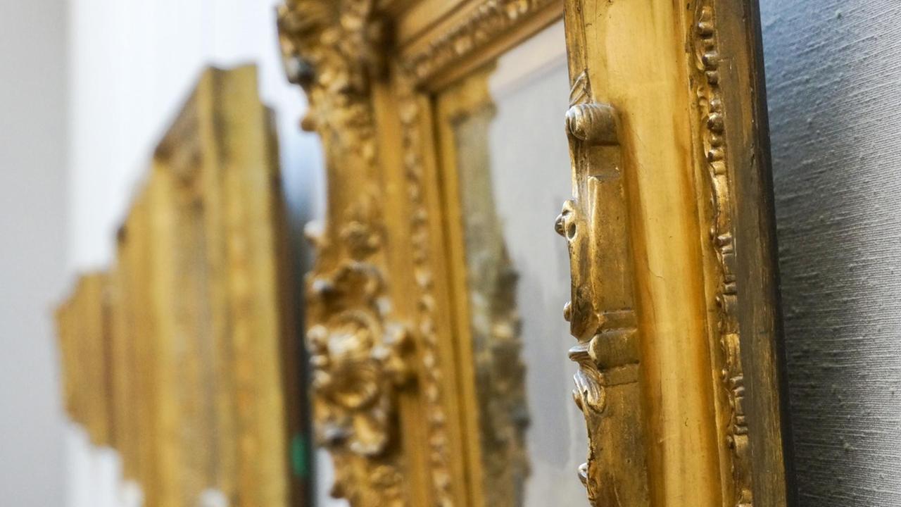 Goldene Bilderrahmen hängen an einer Wand. Goldene Bilderrahmen hängen an einer Wand.