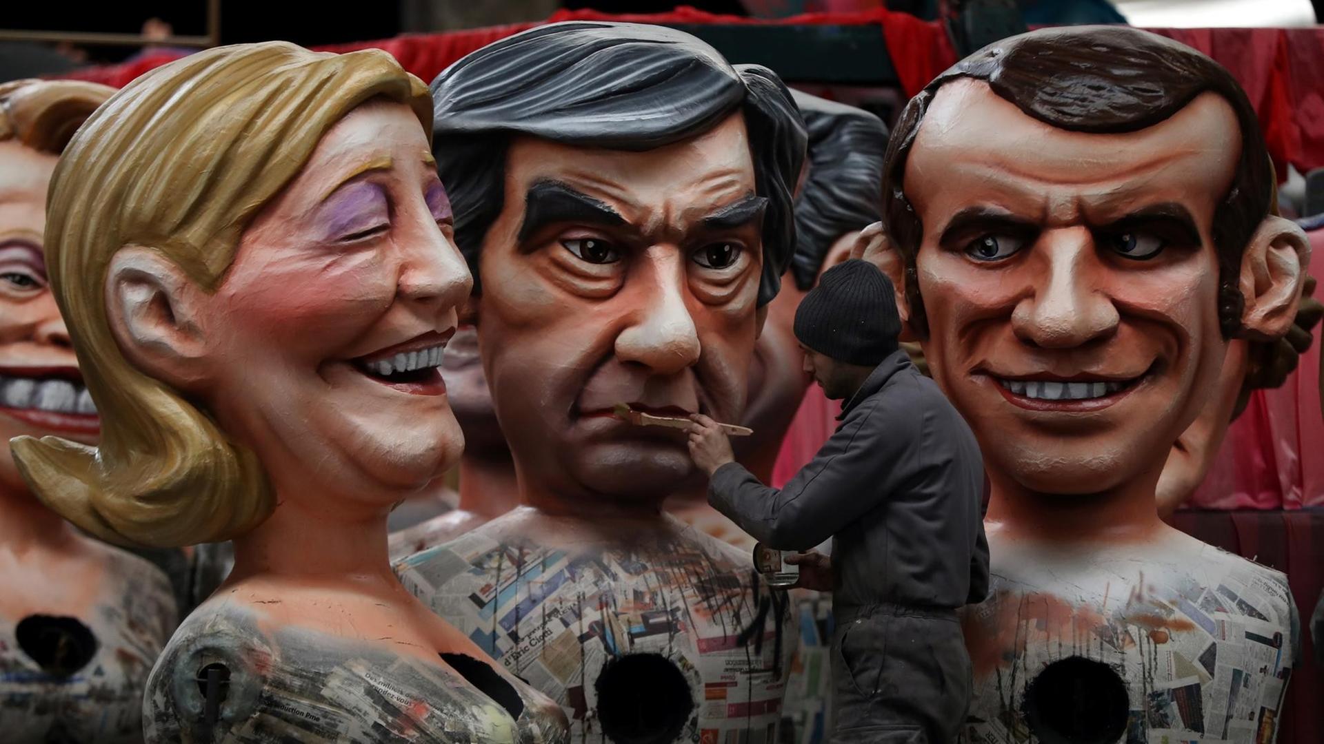 Während des Karnevals von Nizza im Februar 2017 arbeitet ein Mann an drei riesigen Figuren der französischen Präsidentschaftskandidaten Marine Le Pen, Francois Fillon und Emmanuel Macron. Während des Karnevals von Nizza im Februar 2017 arbeitet ein Mann an drei riesigen Figuren der französischen Präsidentschaftskandidaten Marine Le Pen, Francois Fillon und Emmanuel Macron.