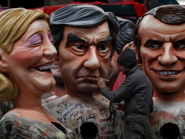 Während des Karnevals von Nizza im Februar 2017 arbeitet ein Mann an drei riesigen Figuren der französischen Präsidentschaftskandidaten Marine Le Pen, Francois Fillon und Emmanuel Macron.