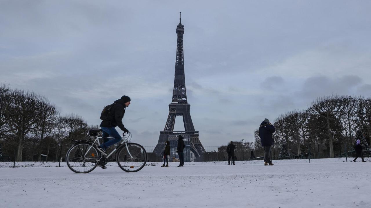 Das Foto zeigt einen Radfahrer vor dem Eiffelturm.