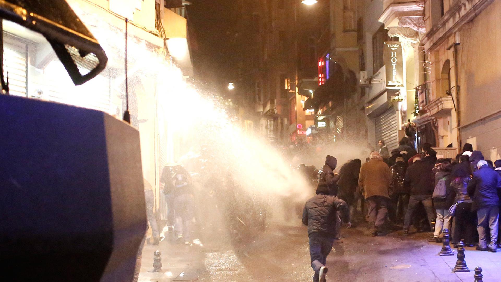 Demonstranten fliehen vor einem Wasserwerfer der Polizei. Demonstranten fliehen vor einem Wasserwerfer der Polizei.
