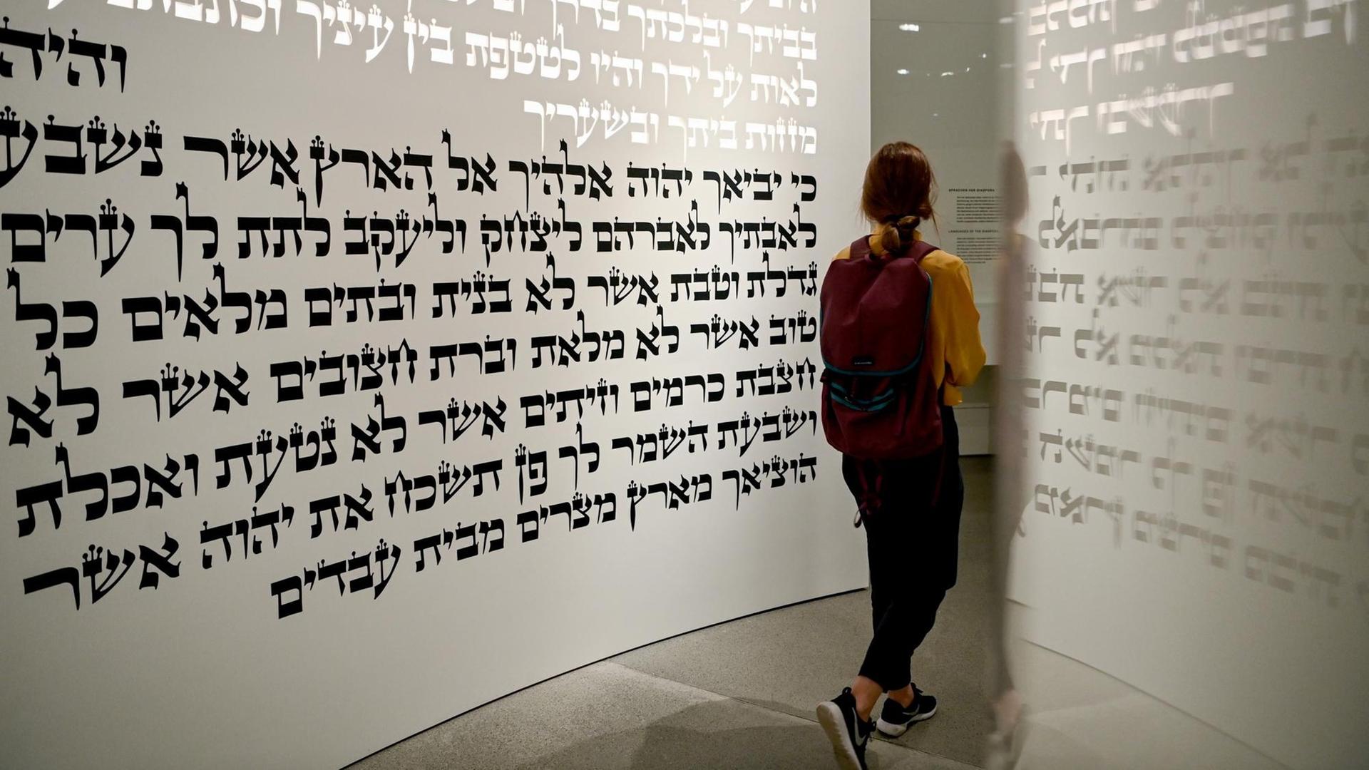 Eine junge Frau geht in der neuen Dauerausstellung «Jüdische Geschichte und Gegenwart in Deutschland» im Liebeskind-Bau des Jüdischen Museums durch den Themenraum «Tora». Eine junge Frau geht in der neuen Dauerausstellung «Jüdische Geschichte und Gegenwart in Deutschland» im Liebeskind-Bau des Jüdischen Museums durch den Themenraum «Tora».