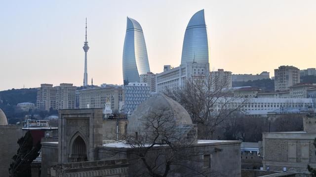 Panorama der aserbaidschanischen Hauptstadt Baku im Sonnenuntergang, zu sehen sind unter anderem der Fernsehturm und die charakteristischen Wolkenkratzer "Flame Towers".