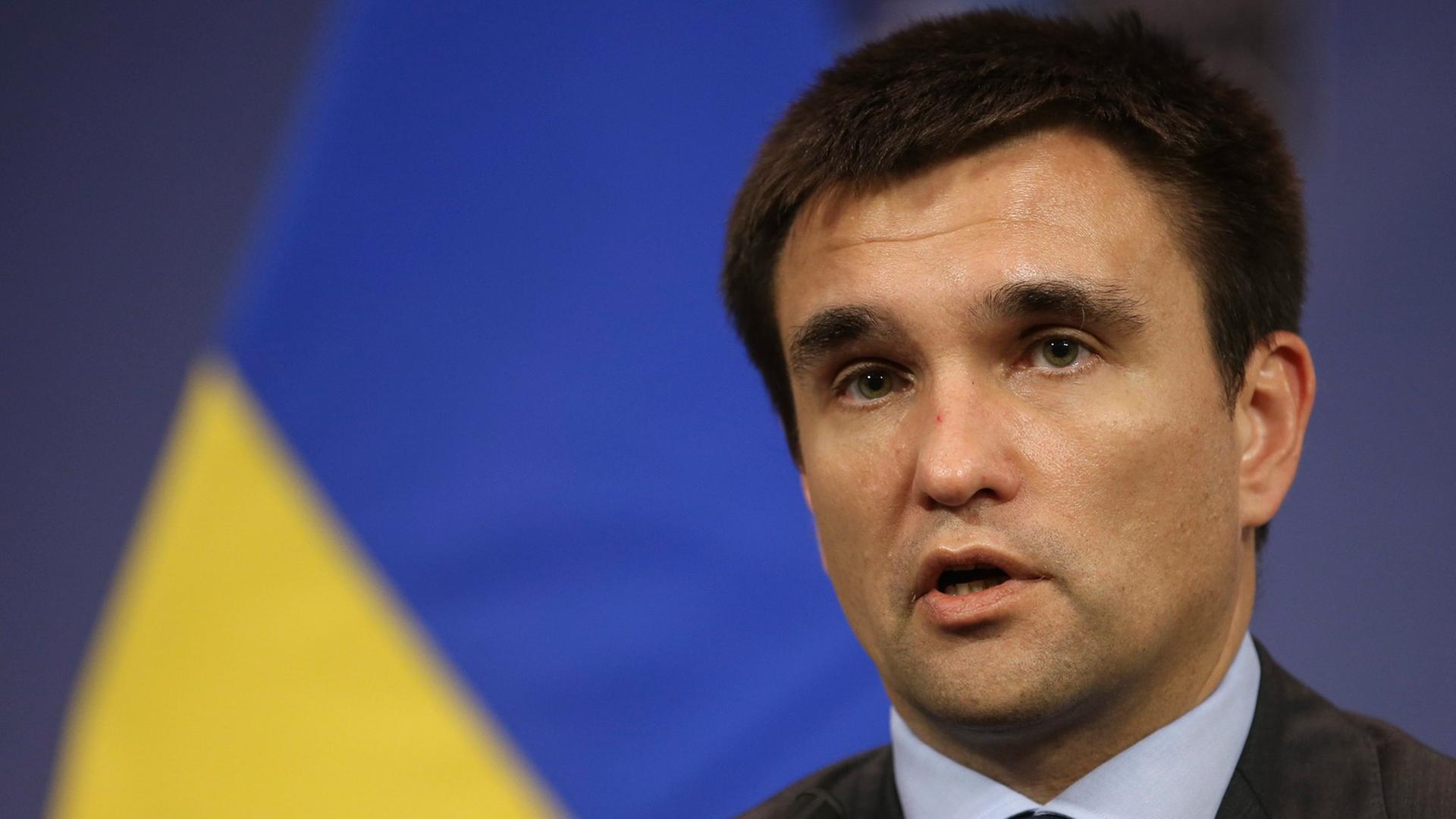 Der ukrainische Außenminster Pawel Klimkin, sprechend, eine gelb-blaue Fahne im Hintergrund. Der ukrainische Außenminster Pawel Klimkin, sprechend, eine gelb-blaue Fahne im Hintergrund.
