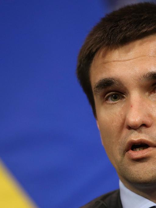 Der ukrainische Außenminster Pawel Klimkin, sprechend, eine gelb-blaue Fahne im Hintergrund.