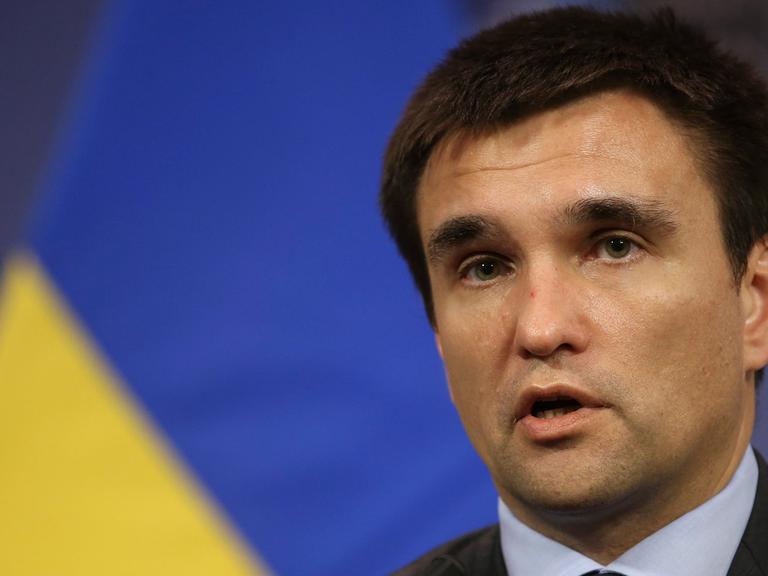 Der ukrainische Außenminster Pawel Klimkin, sprechend, eine gelb-blaue Fahne im Hintergrund.