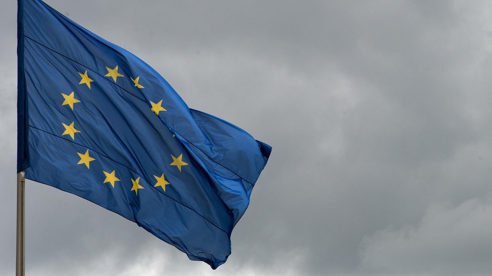 Die Flagge der Europäischen Union weht vor wolkenverhangenem Himmel. Die Flagge der Europäischen Union weht vor wolkenverhangenem Himmel.