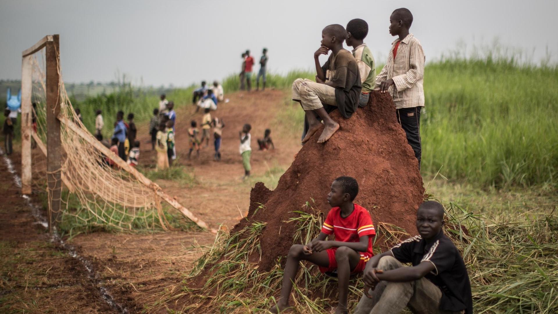 Kinder in einem Flüchtlingscamp im Kongo beobachten ein Fußballspiel.
