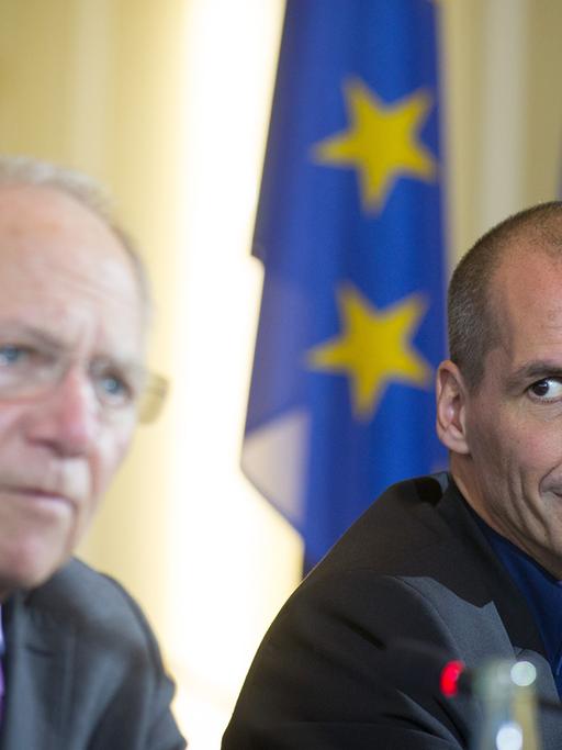 Yanis Varoufakis hört Wolfgang Schäuble zu, wie dieser auf einer gemeinsamen Pressekonferenz spricht.