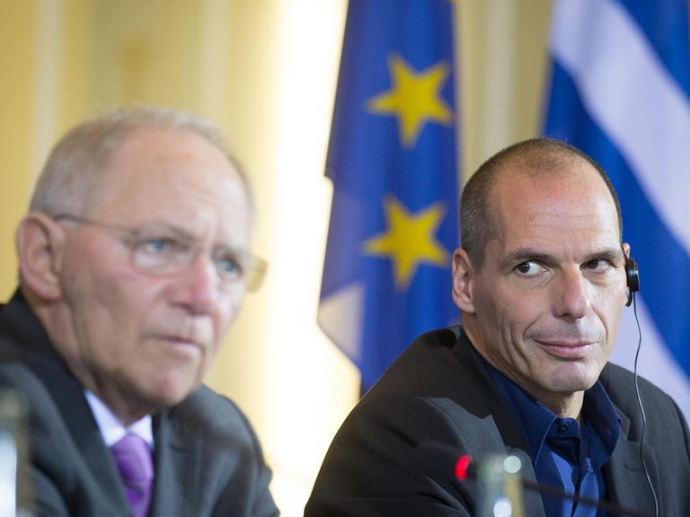 Yanis Varoufakis hört Wolfgang Schäuble zu, wie dieser auf einer gemeinsamen Pressekonferenz spricht.