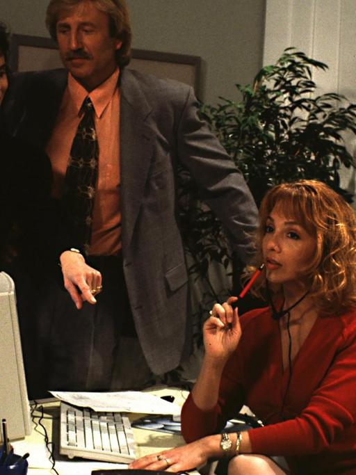 Mann und Frau stehen im Büro, am Schreibtisch sitzt verführerisch die Sekretärin: Ausschnitt aus der Serie "Ehen vor Gericht".
