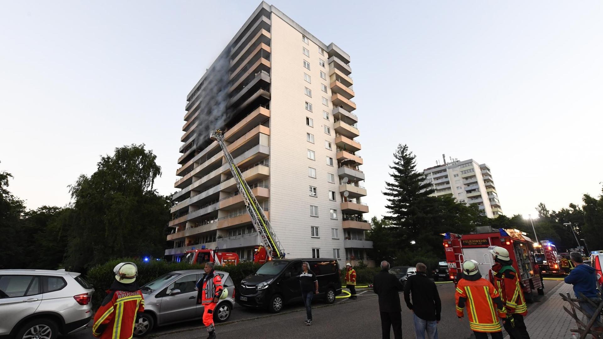 Feuerwehrleute stehen vor einem Hochhaus in Stutensee bei Karlsruhe. Das Feuer war in einer Wohnung im siebten Obergeschoss des 13-stöckigen Mehrfamilienhauses ausgebrochen. Feuerwehrleute stehen vor einem Hochhaus in Stutensee bei Karlsruhe. Das Feuer war in einer Wohnung im siebten Obergeschoss des 13-stöckigen Mehrfamilienhauses ausgebrochen.