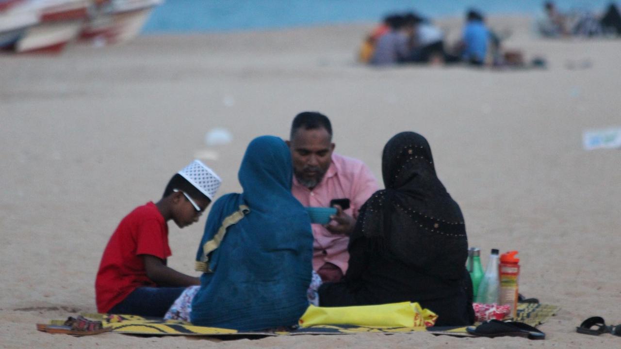 Ein zerbrechliches Idyll - muslimische Familie beim Fastenbrechen am Strand