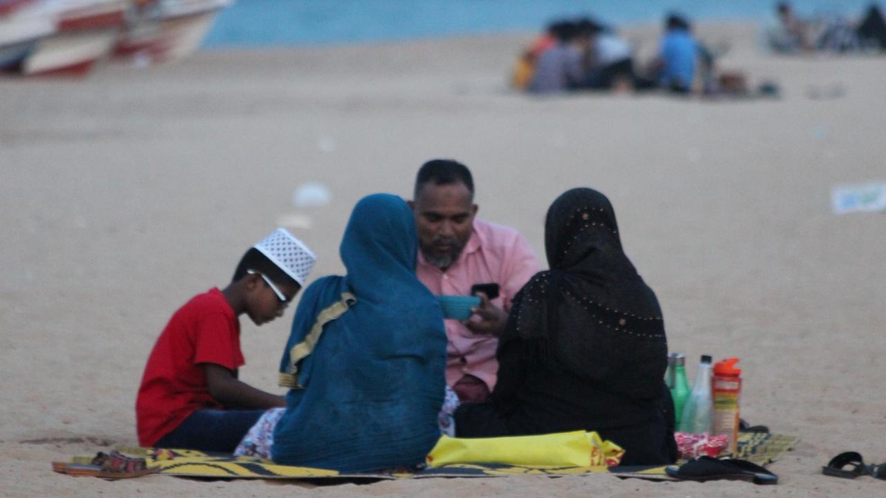 Ein zerbrechliches Idyll - muslimische Familie beim Fastenbrechen am Strand Ein zerbrechliches Idyll - muslimische Familie beim Fastenbrechen am Strand