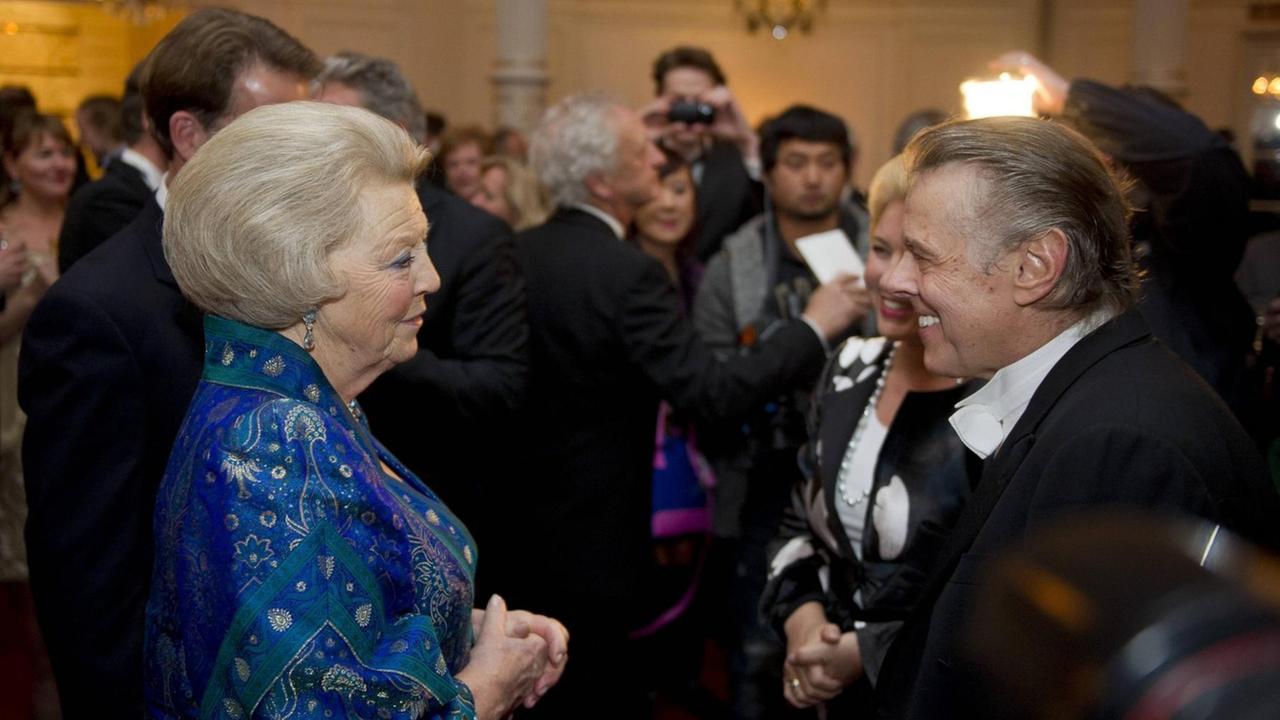 Königin Beatrix der Niederlande und Mariss Jansons stehen sich im Gedränge gegenüber.