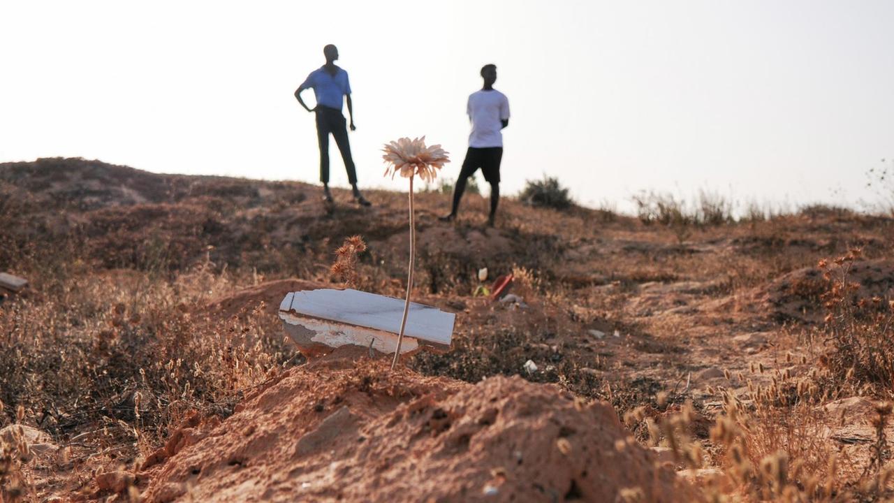 Mamadou Kamarra (links), und Ousmane Koulibali aus Mali stehen am "Friedhof der Unbekannten"in Zarzis/ Tunesien