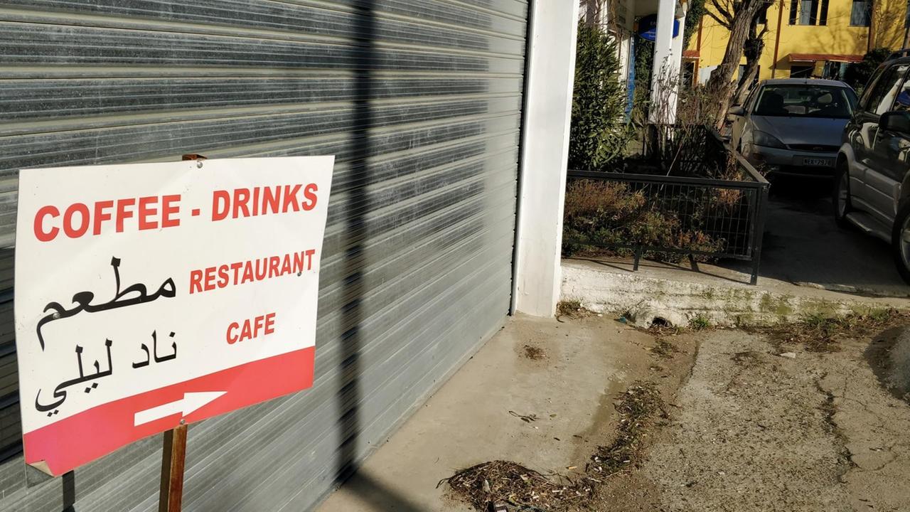Auf einen Schild steht in Englisch und Arabisch "Kaffee, Drink, Restaurant" Auf einen Schild steht in Englisch und Arabisch "Kaffee, Drink, Restaurant"