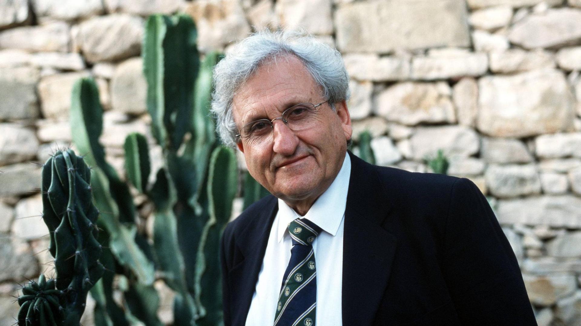 Porträt des Autors Abraham Yehoshua. Er steht vor einer Steinwand und Kakteenpflanzen. Porträt des Autors Abraham Yehoshua. Er steht vor einer Steinwand und Kakteenpflanzen.
