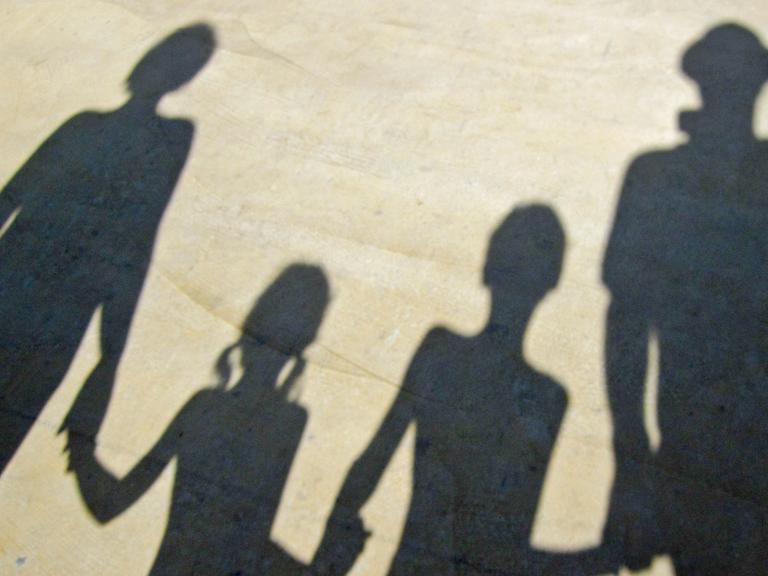 Der Schatten einer Familie, die sich an der Hand hält.