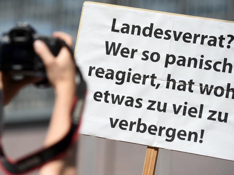 Ein Teilnehmer einer Demonstration von Unterstützern des Internetportals "netzpolitik.org" hält in Berlin bei der Demonstration ein Schild "Landesverrat? Wer so panisch reagiert, hat wohl etwas zu viel zu verbergen!" in der Hand.