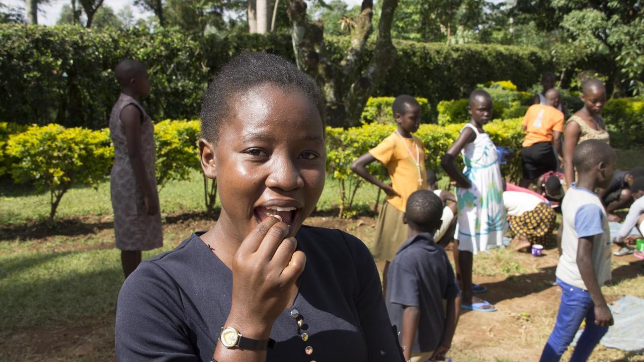 Eine junge afrikanische Frau in blauem Shirt Eine junge afrikanische Frau in blauem Shirt