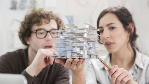 Zwei junge Architekten betrachten ein Modell