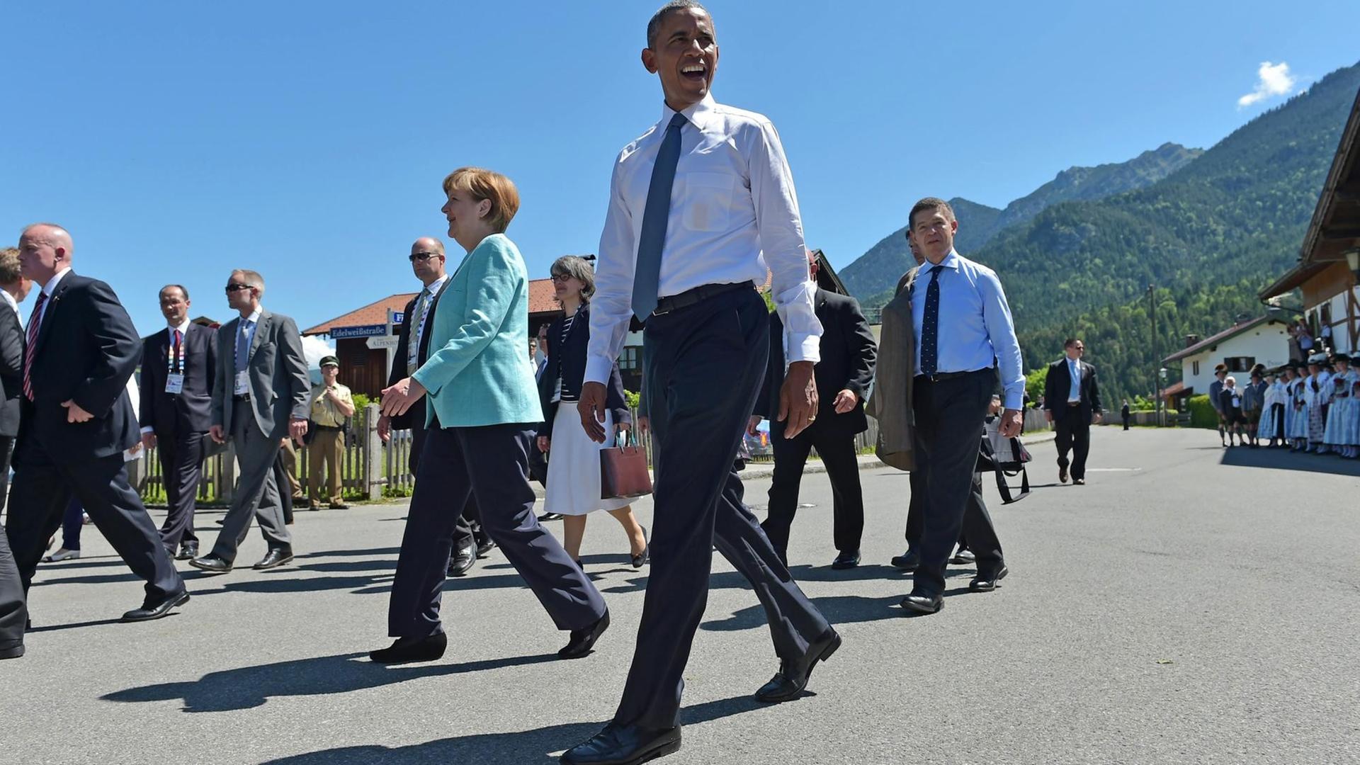 US-Präsident Barack Obama und Kanzlerin Angela Merkel mit ihrem Mann Joachim Sauer (rechts) laufen durch Krün bei Garmisch-Partenkirchen. US-Präsident Barack Obama und Kanzlerin Angela Merkel mit ihrem Mann Joachim Sauer (rechts) laufen durch Krün bei Garmisch-Partenkirchen.