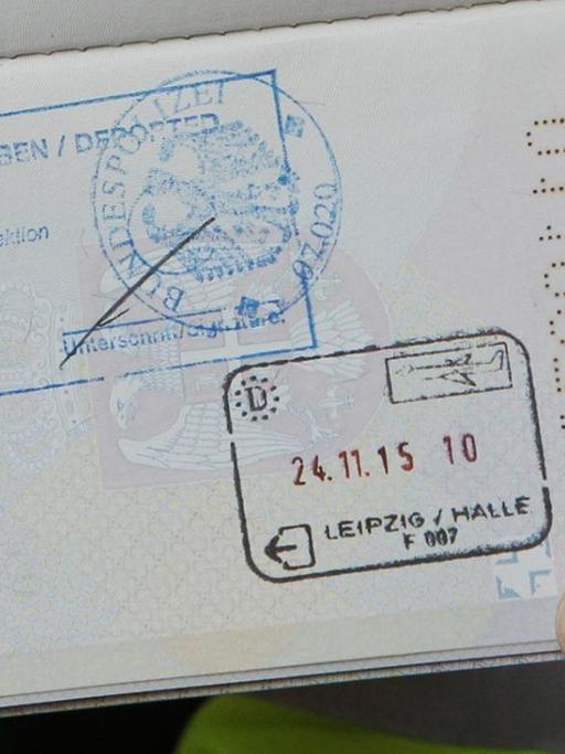 Ein Polizist zeigt den serbischen Pass eines abgelehnten Asylbewerbers mit dem Stempel "Abgeschoben" auf dem Flughafen Leipzig-Halle.