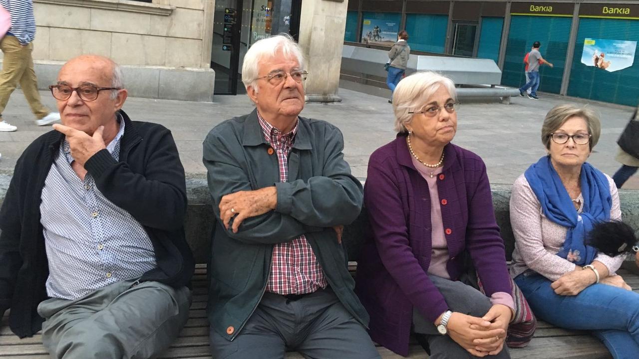 Die Rentner Jose, Manuel, Carmen und Laura sitzen auf einer  Bank auf dem Rathausplatz von Hospitalet del Llobregat am 20.09.2017