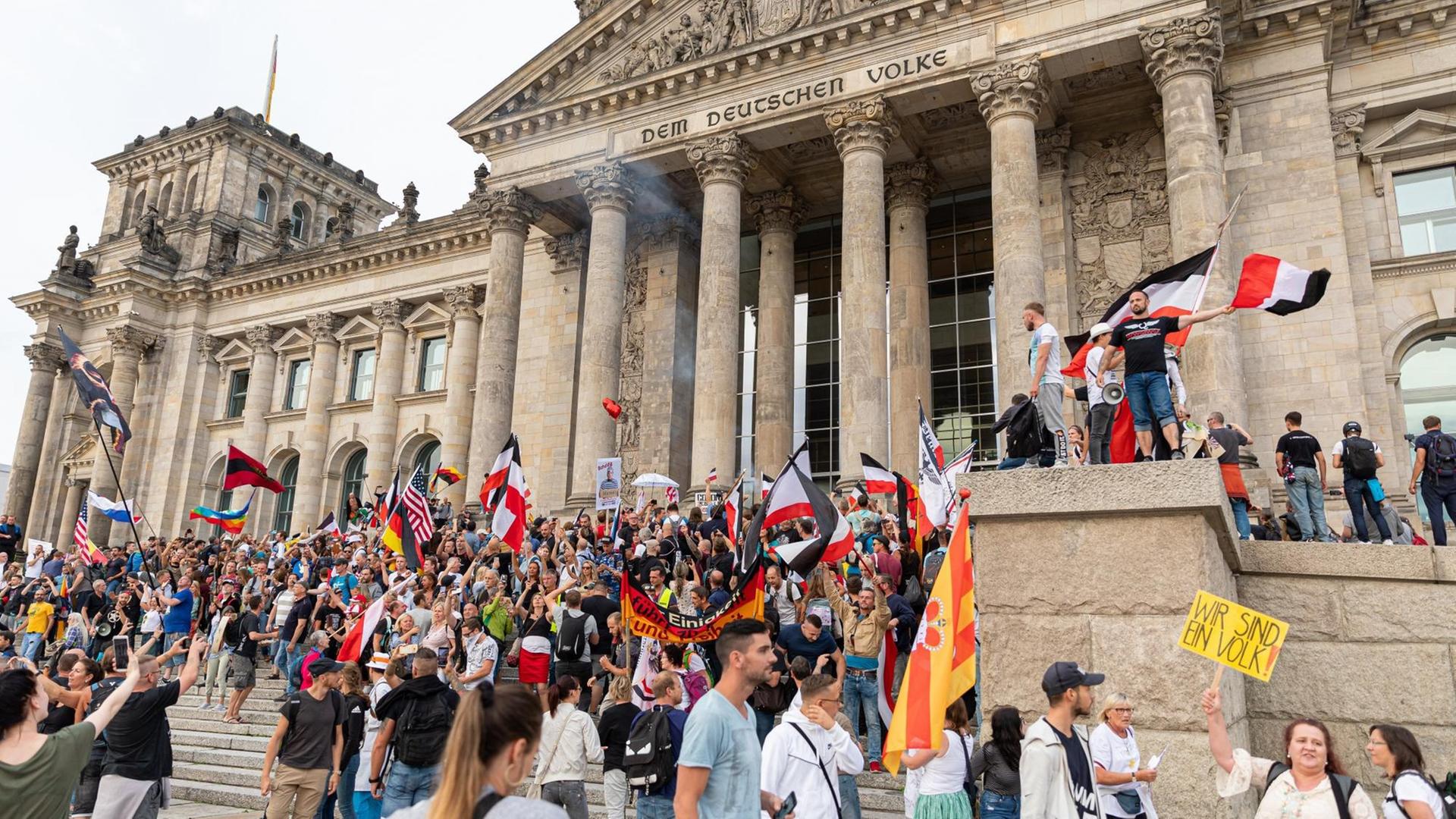 Teilnehmer einer Kundgebung gegen die Corona-Maßnahmen stehen auf den Stufen zum Reichstagsgebäude, zahlreiche Reichsflaggen sind zu sehen. Teilnehmer einer Kundgebung gegen die Corona-Maßnahmen stehen auf den Stufen zum Reichstagsgebäude, zahlreiche Reichsflaggen sind zu sehen.