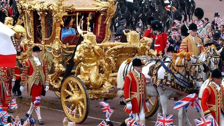 Zahlreiche Schaulustige winken der britischen Königin Elizabeth II. zu, die am 4.6.2002 mit der goldenen Kutsche durch London fährt. Zahlreiche Schaulustige winken der britischen Königin Elizabeth II. zu, die am 4.6.2002 mit der goldenen Kutsche durch London fährt.