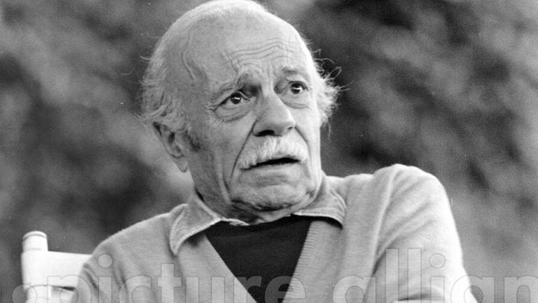 Ein Schwarz-Weiß-Foto zeigt den argentinischen Schriftsteller Ernesto Sábato im Alter von 86 Jahren in Strickjacke in einem Gartenstuhl sitzend Ein Schwarz-Weiß-Foto zeigt den argentinischen Schriftsteller Ernesto Sábato im Alter von 86 Jahren in Strickjacke in einem Gartenstuhl sitzend
