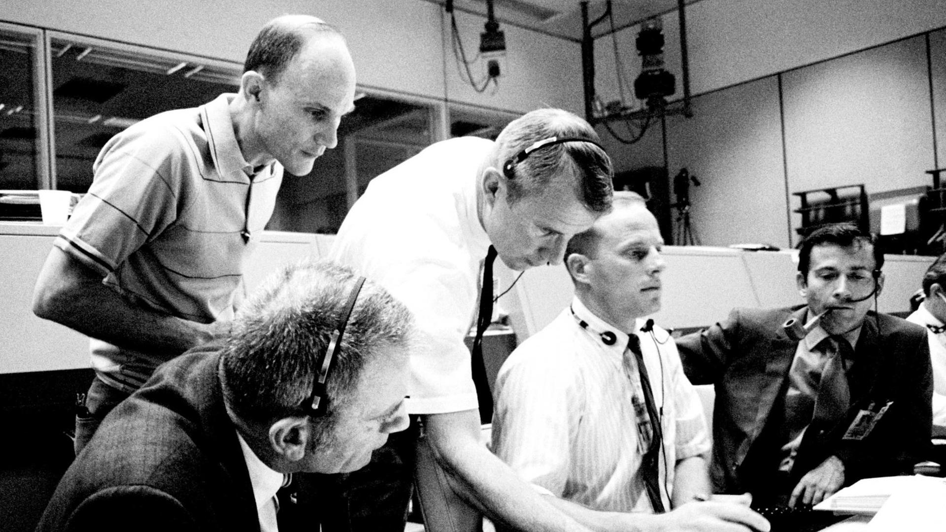 Anspannung im Kontrollzentrum während der Rettung von Apollo 13 (ganz rechts mit Pfeife der Astronaut John Young) Anspannung im Kontrollzentrum während der Rettung von Apollo 13 (ganz rechts mit Pfeife der Astronaut John Young)