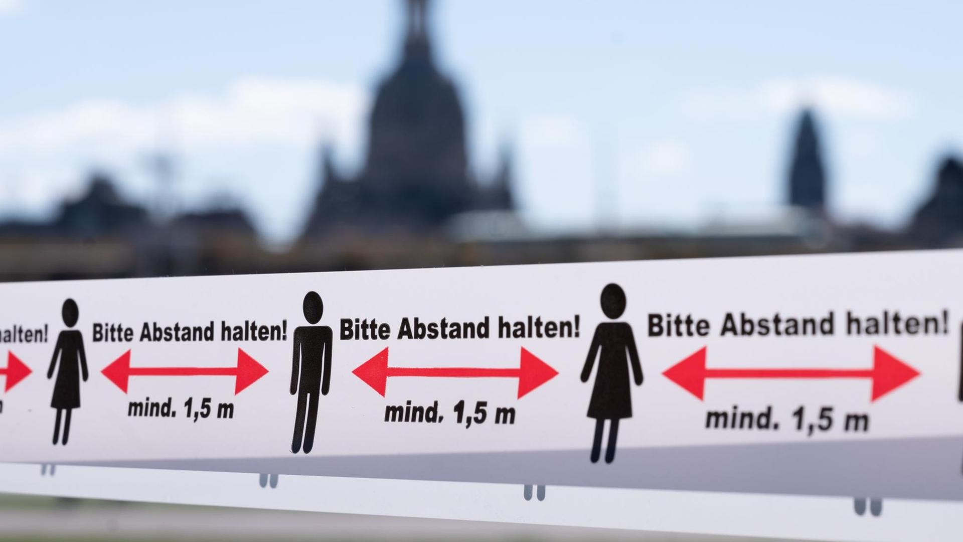 Auf einem Absperr-Band an einem Restaurant steht "Bitte Abstand halten" Auf einem Absperr-Band an einem Restaurant steht "Bitte Abstand halten"