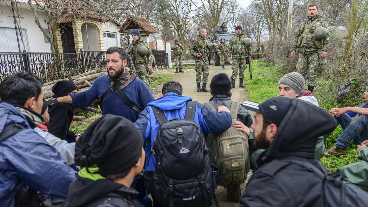 Flüchtlinge aus Idomeni werden in dem mazedonischen Dorf Moin von Soldaten in Gewahrsam genommen. Flüchtlinge aus Idomeni werden in dem mazedonischen Dorf Moin von Soldaten in Gewahrsam genommen.