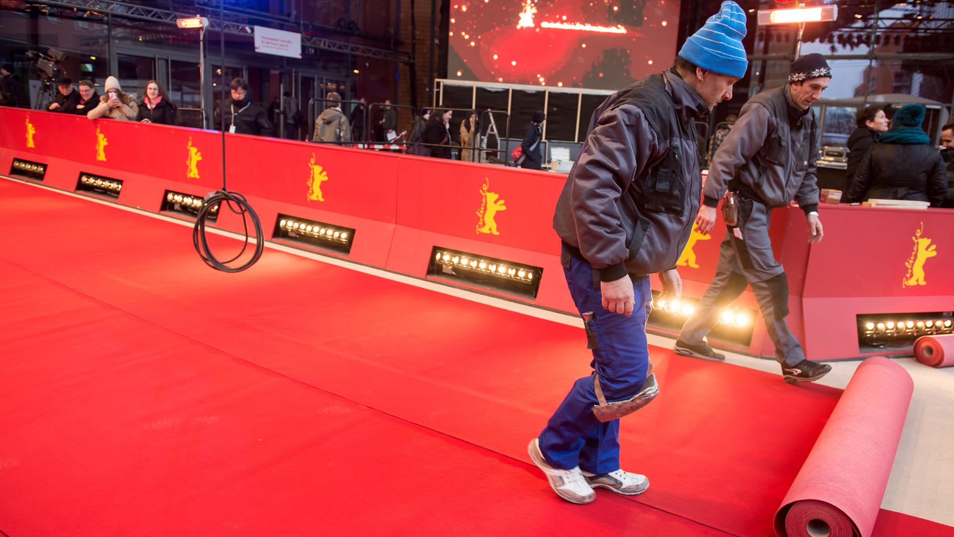 Arbeiter verlegen den Roten Teppich vor dem Berlinale Palast in Berlin. Arbeiter verlegen den Roten Teppich vor dem Berlinale Palast in Berlin.