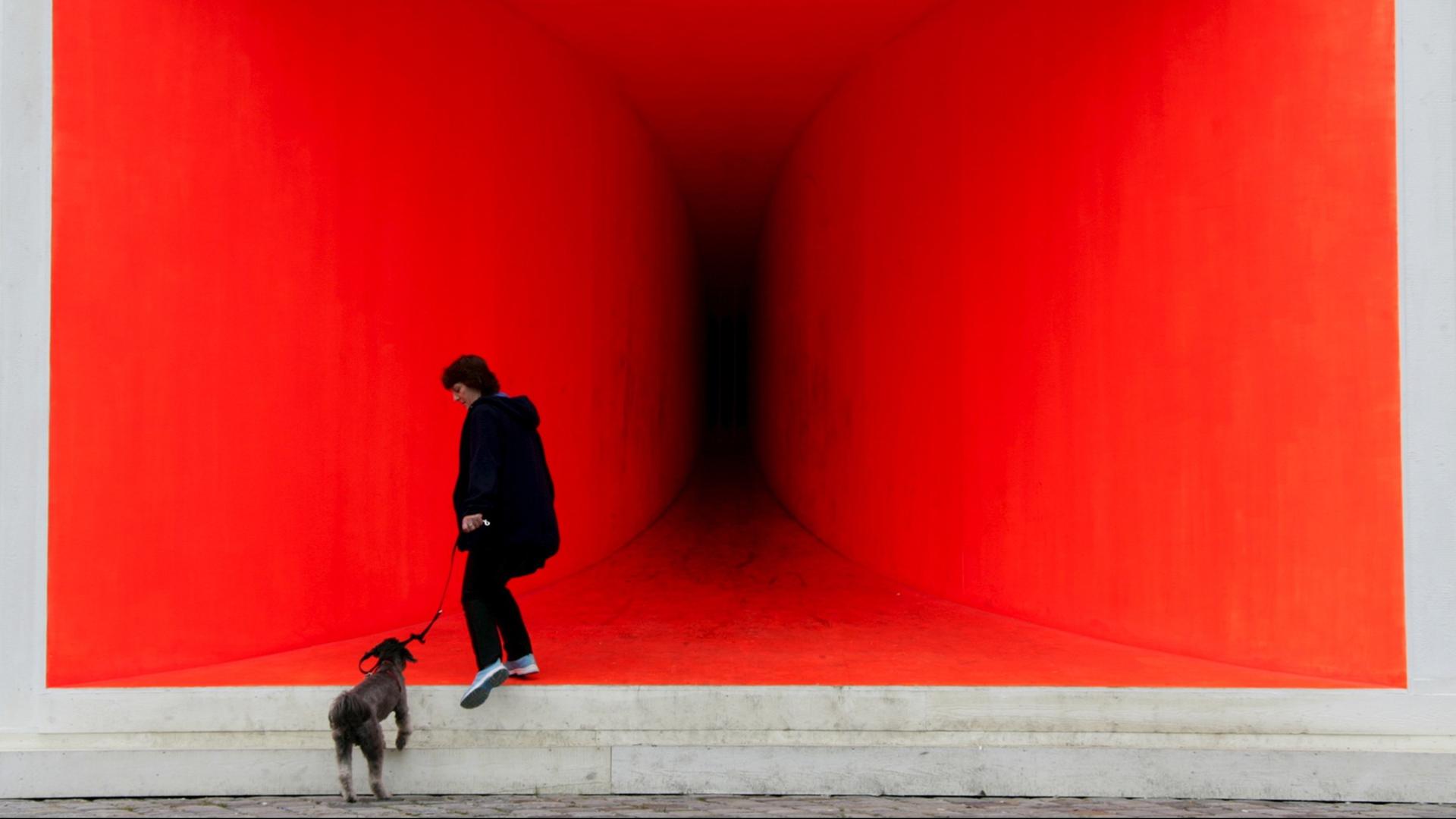 Eine Frau steigt am Münchner Lenbachhaus in einen überdimensionalen Trichterlautsprecher. Zu jeder vollen Stunde sendet die Installation des Künstlers Benjamin Bergmann einen sehr tiefen, brummenden Basston aus, der zwar nicht laut, aber physisch spürbar ist. Eine Frau steigt am Münchner Lenbachhaus in einen überdimensionalen Trichterlautsprecher. Zu jeder vollen Stunde sendet die Installation des Künstlers Benjamin Bergmann einen sehr tiefen, brummenden Basston aus, der zwar nicht laut, aber physisch spürbar ist.