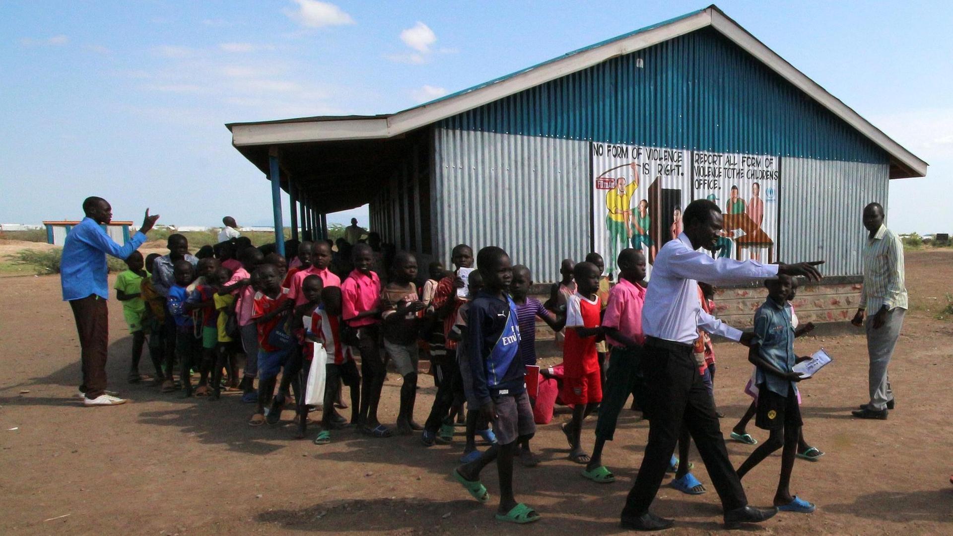 Grundschulkinder in Kakuma vor ihrer aus Wellblech gebauten Schule. Grundschulkinder in Kakuma vor ihrer aus Wellblech gebauten Schule.